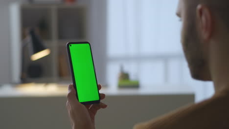 man-is-holding-modern-smartphone-with-green-screen-for-chroma-key-technology-viewing-video-in-social-nets-reading-news-on-sites